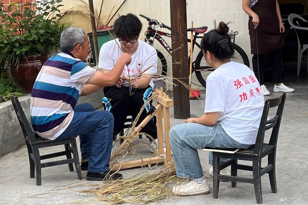 团队成员学习编织草鞋。金沙威尼斯欢乐娱人城供图